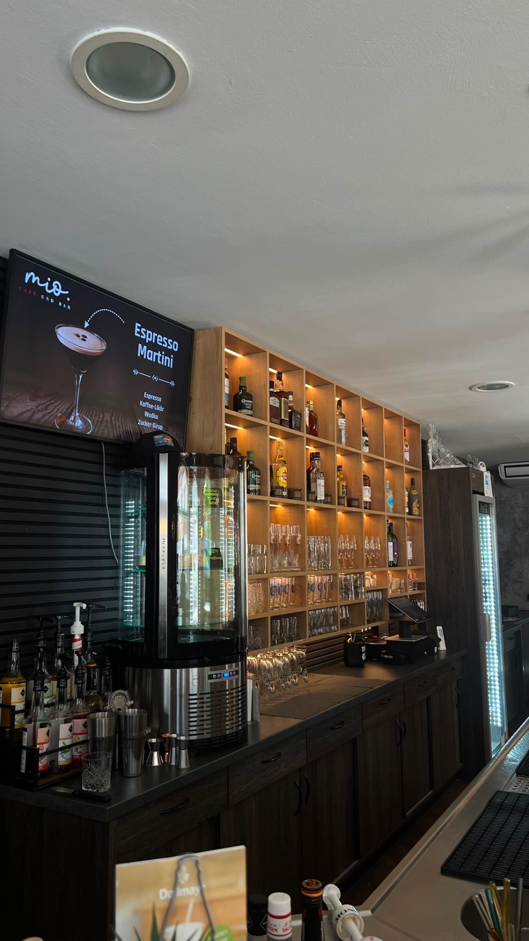 Bar im mio Café und Bar mit beleuchtetem Flaschenregal